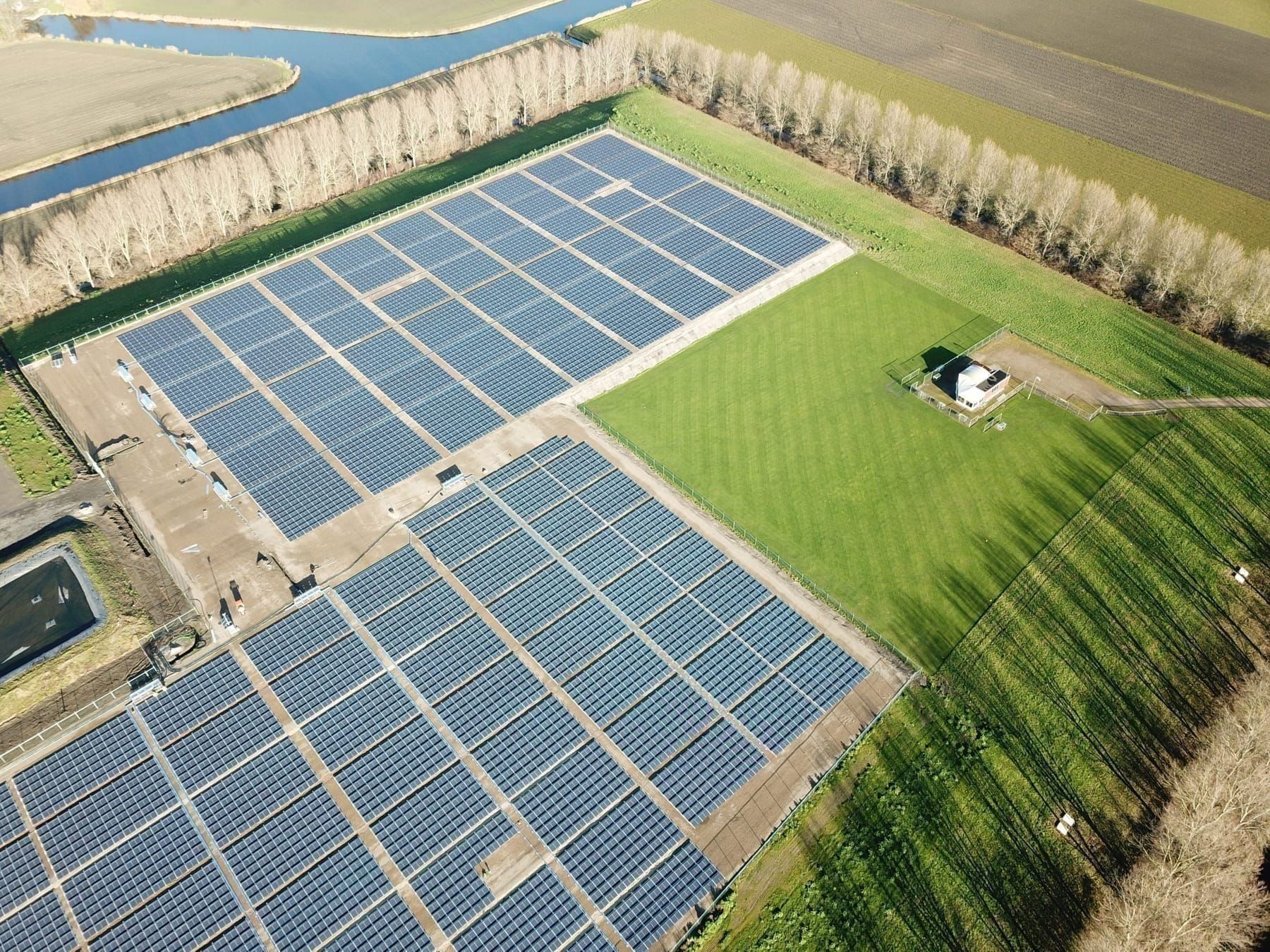 Luchtfoto van een bedrijfsterrein met zonnepanelen op het dak