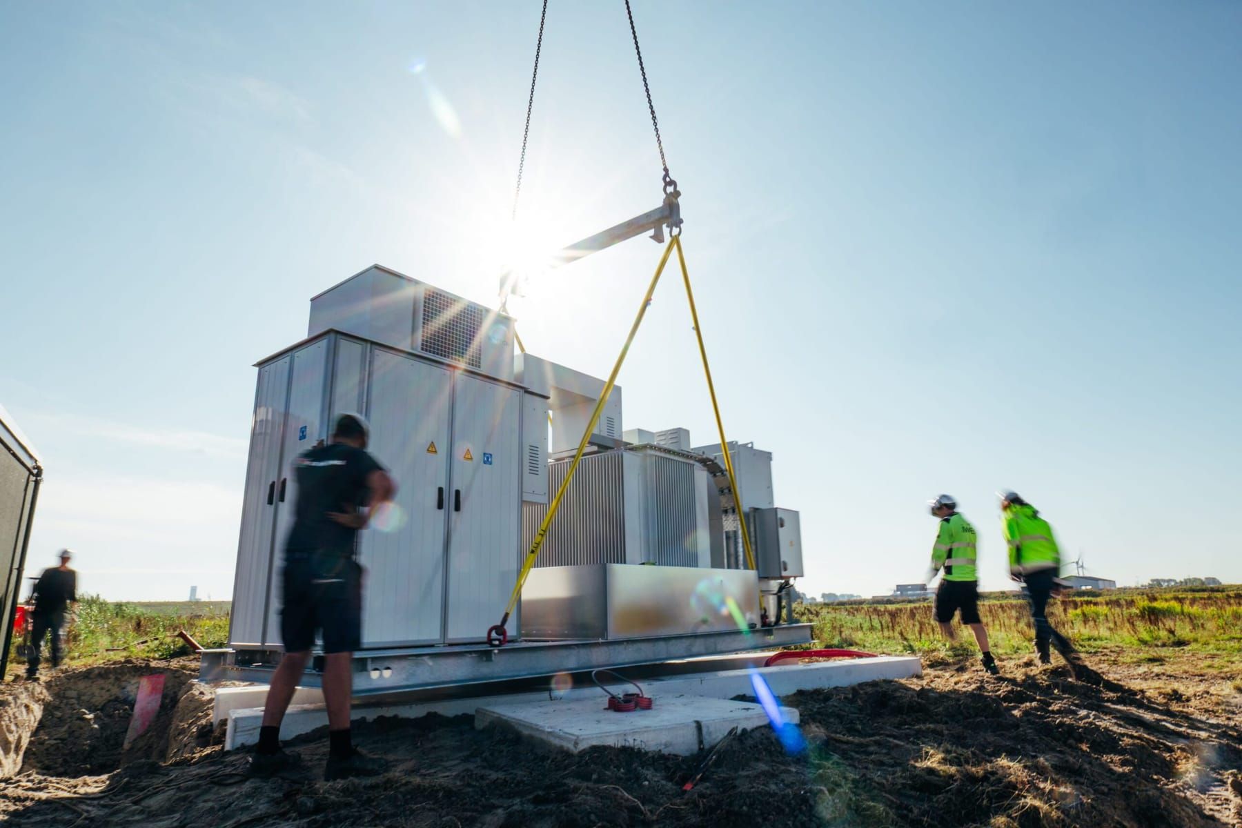 De batterijcontainer wordt met een kraan op zijn plek gehesen op de Energiecampus Leeuwarden
